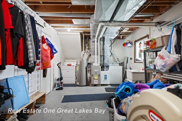 basement featuring water heater, a sink, washer and dryer, and heating unit