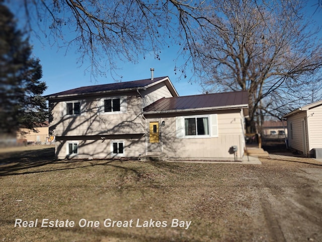 view of front of house featuring metal roof and a front lawn