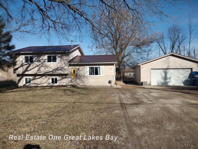 view of front of property with a garage, metal roof, and an outdoor structure