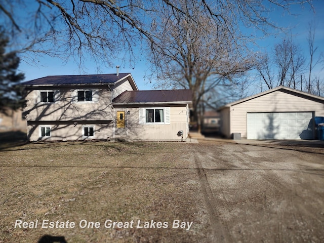 view of front of house featuring an outbuilding, metal roof, and a detached garage