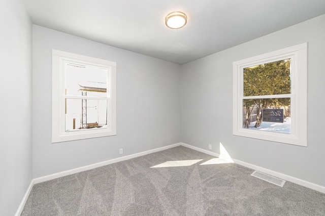 carpeted spare room with baseboards and visible vents