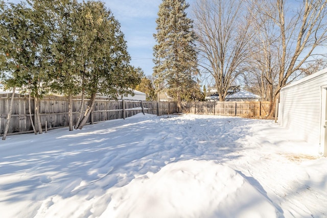 yard covered in snow featuring a fenced backyard