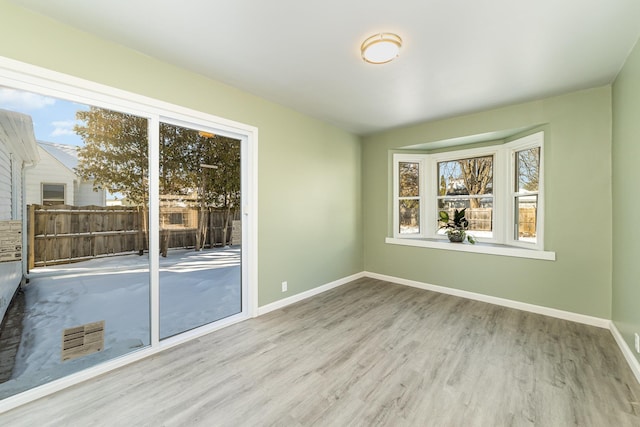 empty room featuring light wood-style floors and baseboards