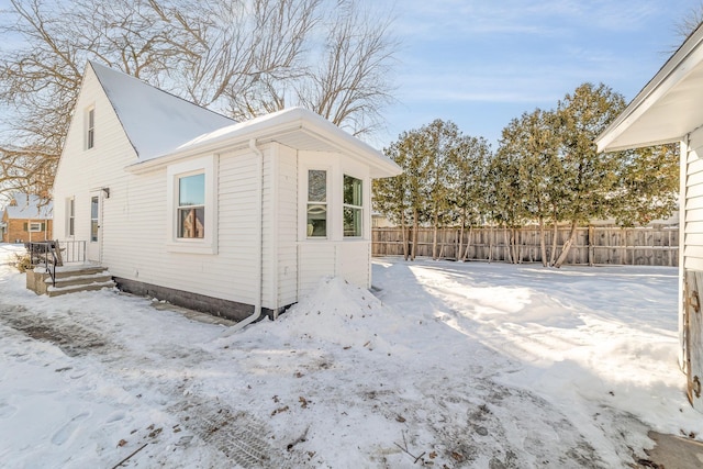 snow covered property featuring fence