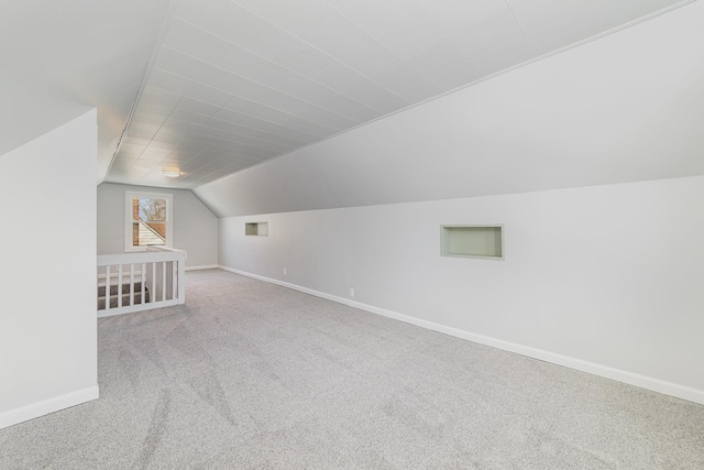 additional living space featuring lofted ceiling, baseboards, visible vents, and carpet flooring