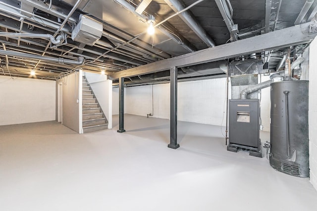 unfinished basement with heating unit, water heater, and stairway