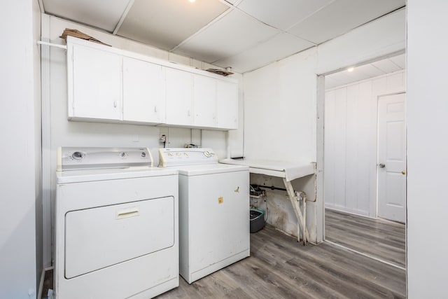 washroom featuring washer and clothes dryer, cabinet space, and light wood-style floors