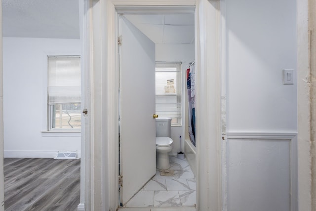 full bathroom featuring toilet, marble finish floor, visible vents, and shower / bath combination with curtain