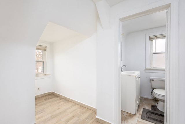 bathroom featuring baseboards, vanity, toilet, and wood finished floors