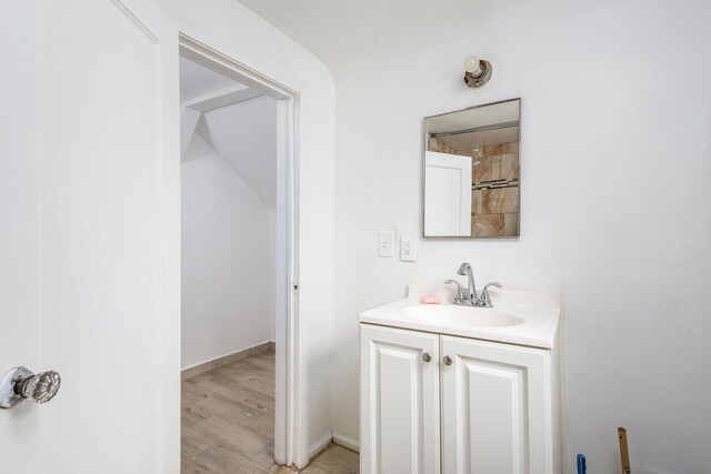 bathroom featuring vanity, baseboards, and wood finished floors