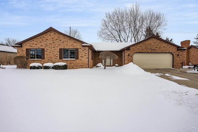 single story home featuring an attached garage, driveway, and brick siding