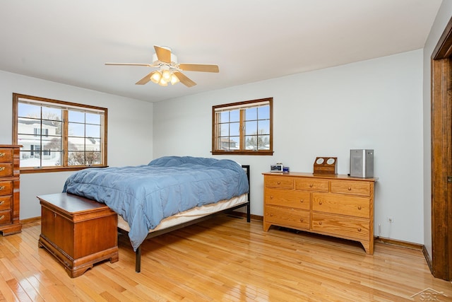 bedroom featuring light wood-type flooring, a ceiling fan, and baseboards