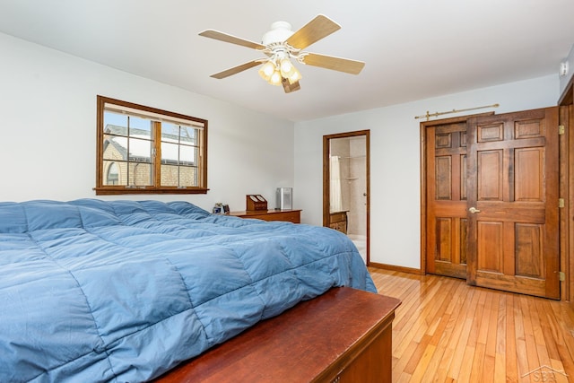 bedroom with light wood-type flooring, ceiling fan, baseboards, and connected bathroom