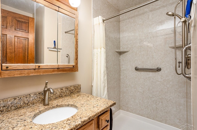 bathroom featuring a tile shower and vanity