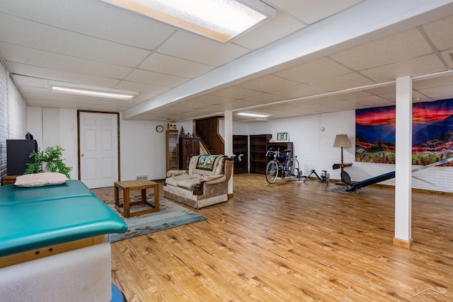 interior space with a drop ceiling and wood finished floors