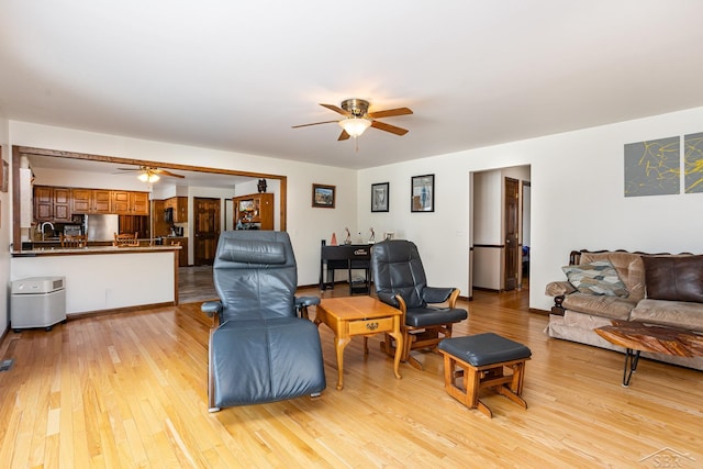 living area with light wood-type flooring and a ceiling fan