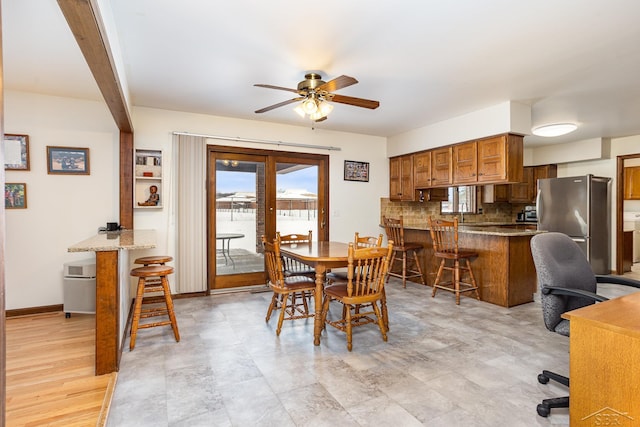 dining area with beamed ceiling, a ceiling fan, and baseboards