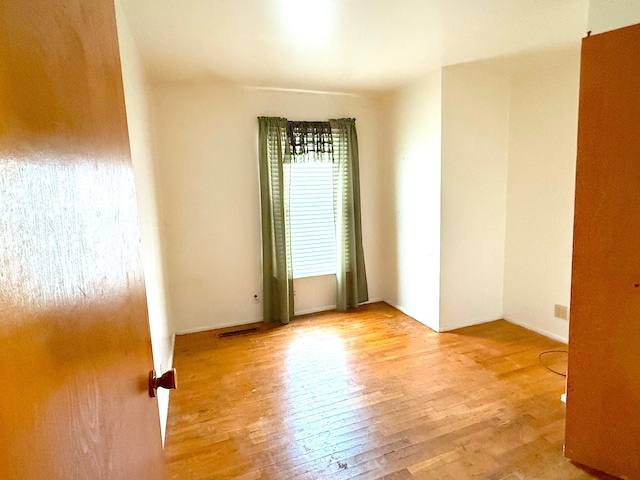 empty room featuring light wood-style flooring and visible vents