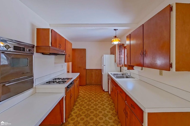 kitchen with wall oven, decorative light fixtures, light countertops, gas stovetop, and a sink