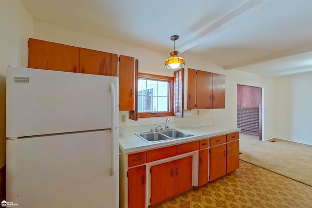 kitchen with light colored carpet, decorative light fixtures, freestanding refrigerator, light countertops, and a sink