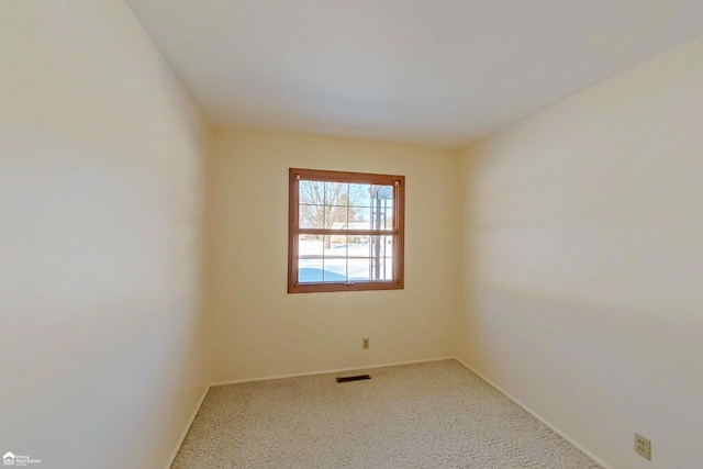 carpeted spare room featuring visible vents