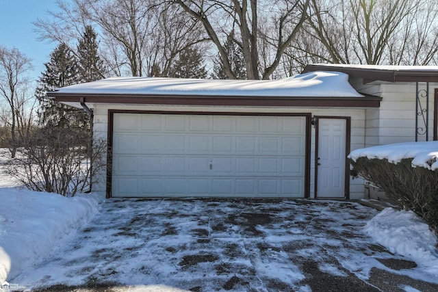 snow covered garage with a detached garage