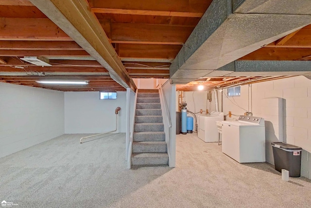 basement with light carpet, washer and clothes dryer, and stairs