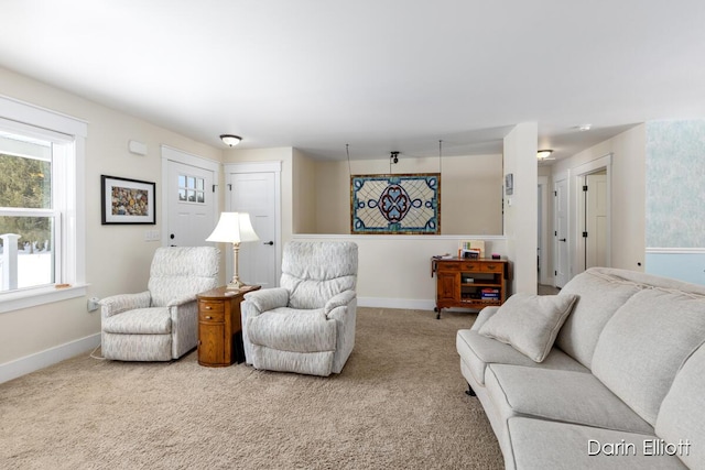 carpeted living area with baseboards