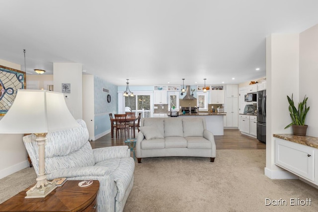 living area with recessed lighting, baseboards, and light colored carpet