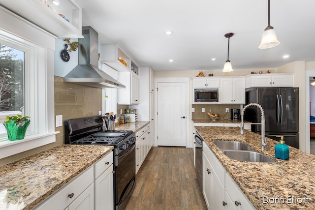 kitchen featuring wall chimney exhaust hood, built in microwave, white cabinets, and gas stove