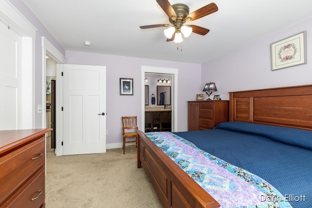 bedroom featuring ensuite bathroom, ceiling fan, baseboards, and light colored carpet