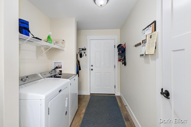 washroom with laundry area, dark wood-style flooring, visible vents, baseboards, and washing machine and clothes dryer