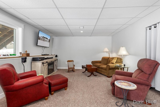 living room with a paneled ceiling, baseboards, and carpet flooring