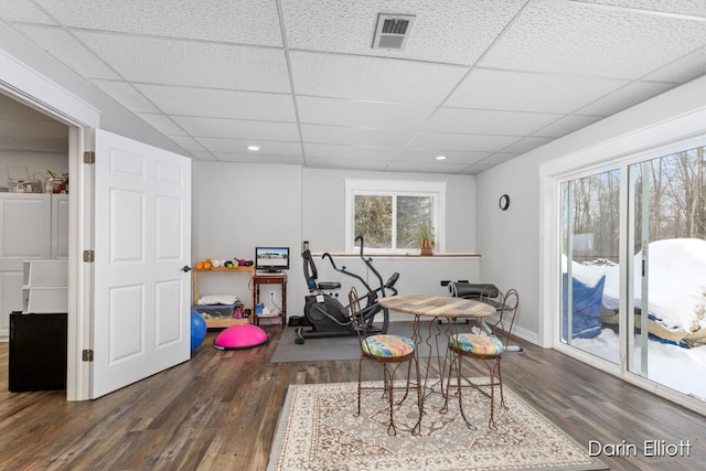 interior space with dark wood-type flooring, a paneled ceiling, and visible vents