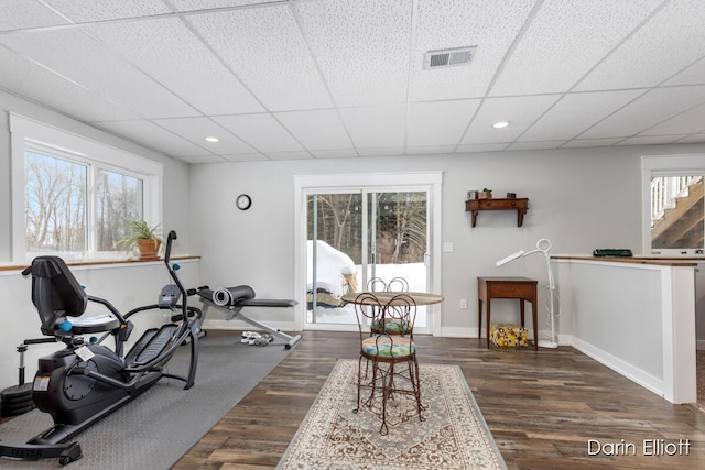 workout area with dark wood-style floors, a healthy amount of sunlight, and visible vents