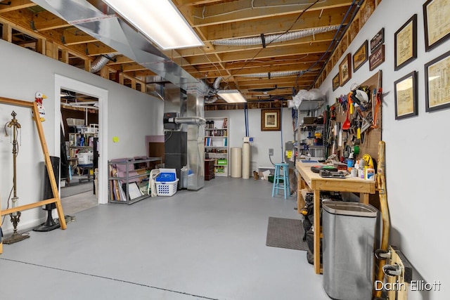 unfinished basement featuring a workshop area and heating unit