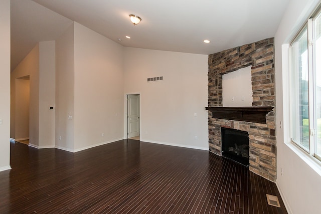 unfurnished living room featuring a stone fireplace, visible vents, and a healthy amount of sunlight