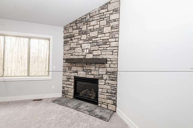 living area with lofted ceiling, light colored carpet, visible vents, a stone fireplace, and baseboards