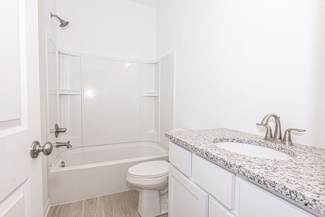 bathroom with wood finished floors, shower / washtub combination, toilet, and vanity