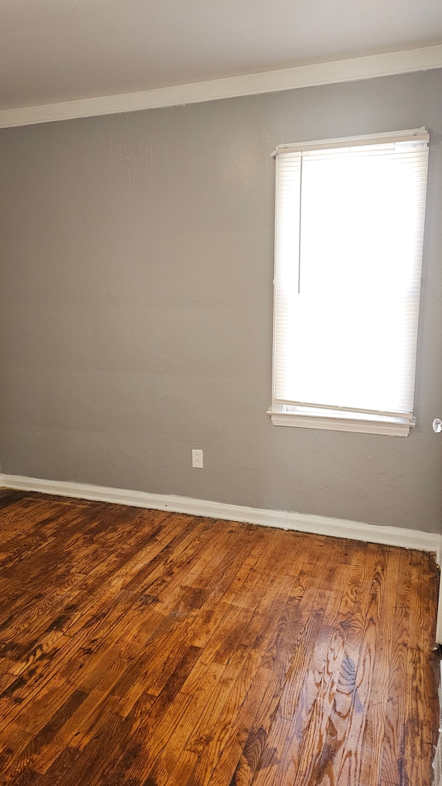 unfurnished room with baseboards and wood finished floors