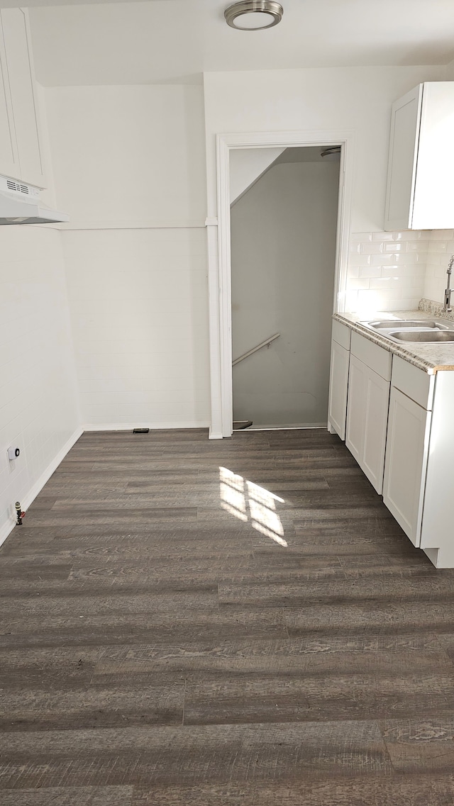 interior space with a sink, dark wood finished floors, and baseboards