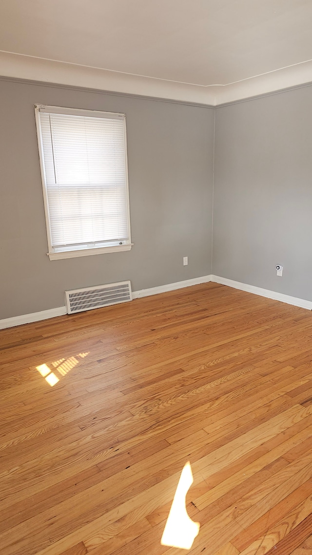 unfurnished room with baseboards, visible vents, and light wood finished floors