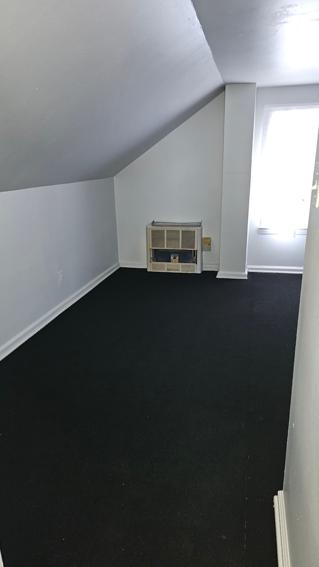 bonus room with lofted ceiling and baseboards