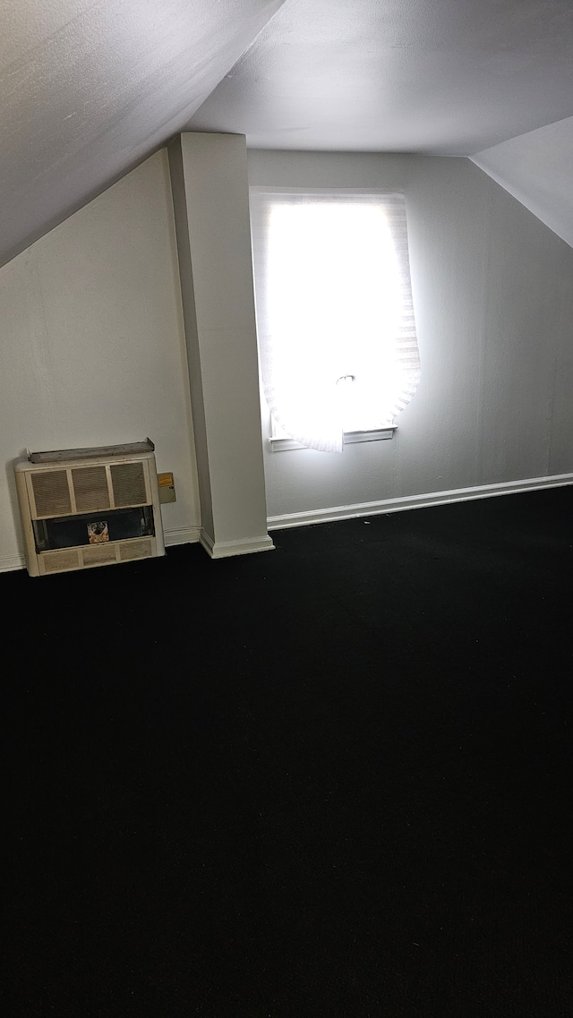 bonus room featuring lofted ceiling, heating unit, and baseboards