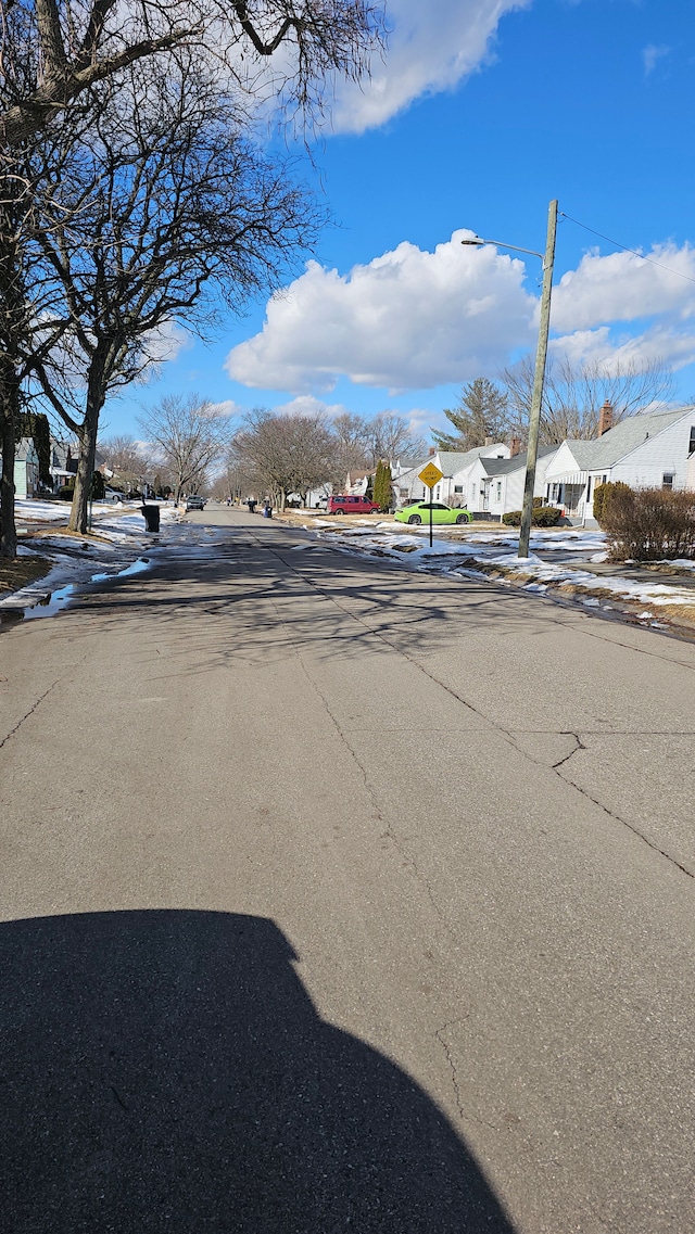 view of road with traffic signs, a residential view, and sidewalks