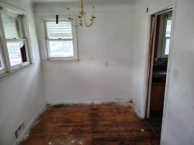 18401 Justine St, Detroit, MI 48234 - unfurnished dining area with wood-type flooring, baseboards, an inviting chandelier, and visible vents