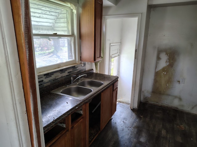 18401 Justine St, Detroit, MI 48234 - kitchen with dark wood-style flooring, dark countertops, a sink, brown cabinetry, and tasteful backsplash