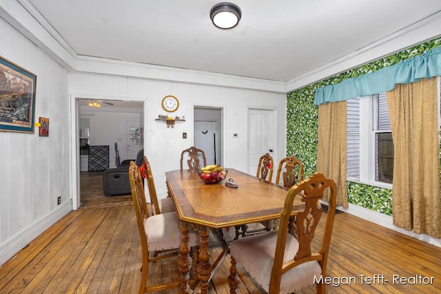 dining space featuring wood finished floors and baseboards