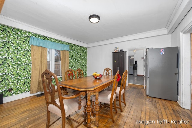 dining space with ornamental molding and wood finished floors