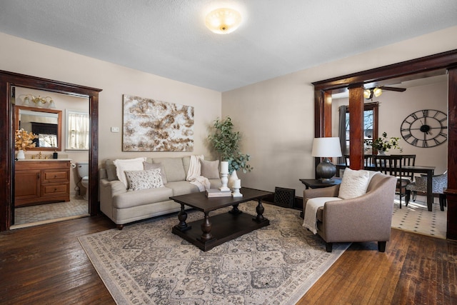 living area featuring dark wood-style floors, a textured ceiling, and plenty of natural light